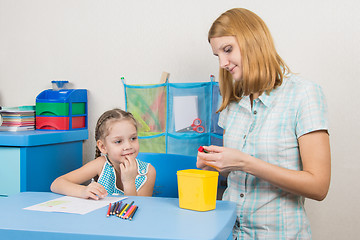 Image showing Five-year girl with interest looks like mom sharpens pencils