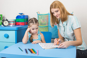 Image showing The girl does not understand the course material that speaks to her tutor