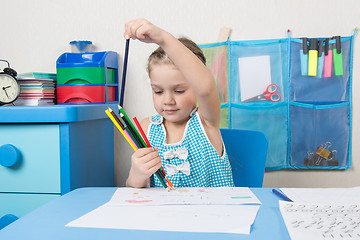 Image showing Happy five year old girl chose the correct pencil from the heap