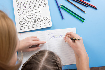 Image showing My mother helps the child to spell the letters of the alphabet, a top view