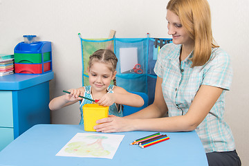 Image showing My mother helps the child to sharpen pencils