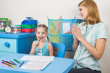 Image showing Five-year girl and a tutor is fun sitting at the table and enjoy