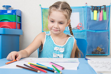 Image showing Upset girl draws with crayons