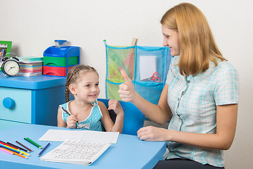 Image showing Mentor happily shows the five-year girl thumbs up, congratulating her