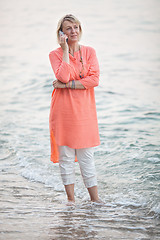 Image showing Woman talking on mobile phone at the seaside