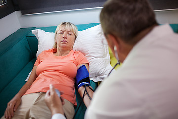 Image showing Doctor checking womans blood pressure