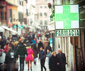 Image showing Pharmacy sign hanging on the building in crowded street