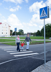 Image showing Family of three crossing the road.