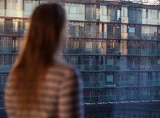 Image showing Woman looking at an apartment block