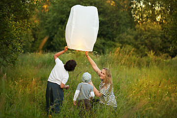 Image showing Mother with her sons flying paper lantern