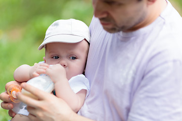 Image showing Father feeding his baby from the bottle