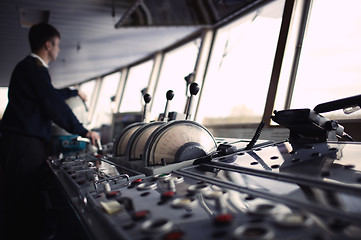 Image showing Navigation officer driving ship on the river.