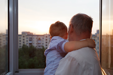 Image showing Grandfather and grandson embracing on the balcony