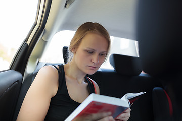 Image showing Woman reading a book in the car