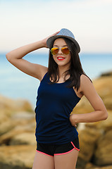 Image showing Young smiling girl in grey hat and sun glasses