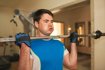 Image showing Strong young man exercising with barbell