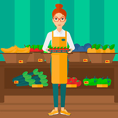 Image showing Supermarket worker with box full of apples.