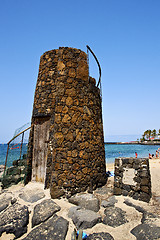 Image showing tower  yellow  beach    black rocks in the   lanzarote 