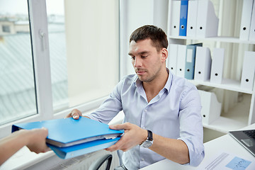 Image showing businessman taking folder from secretary in office