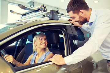 Image showing happy couple buying car in auto show or salon