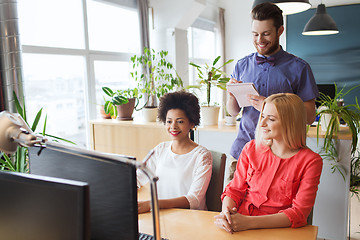 Image showing happy creative team with computer in office