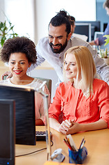 Image showing happy creative team with computer in office