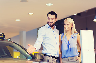 Image showing happy couple buying car in auto show or salon