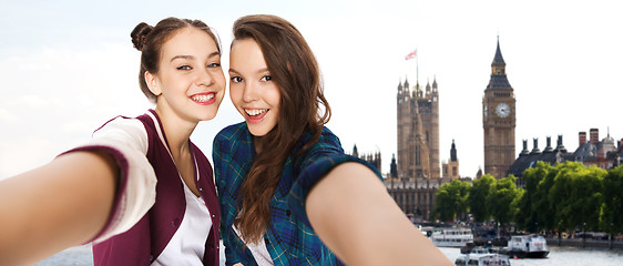 Image showing happy teenage girls taking selfie in london