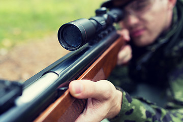 Image showing close up of soldier or hunter with gun in forest