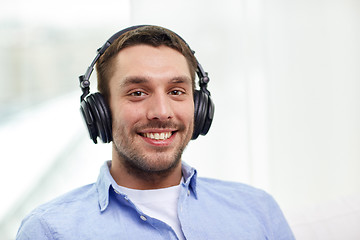 Image showing smiling young man in headphones at home