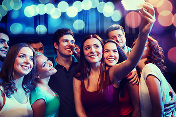 Image showing friends with smartphone taking selfie in club