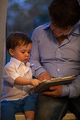 Image showing Man and little boy playing with tablet