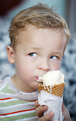 Image showing Cute little boy eating an ice cream cone