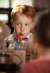 Image showing Little boy drinking with tubule