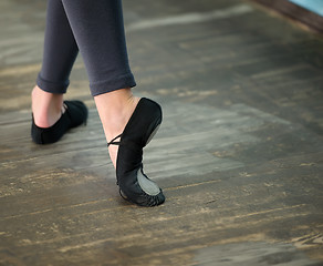 Image showing Close up view to ballerinas legs in pointes on wooden floor