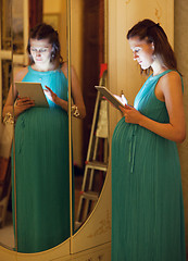 Image showing Pregnant woman using tablet at home