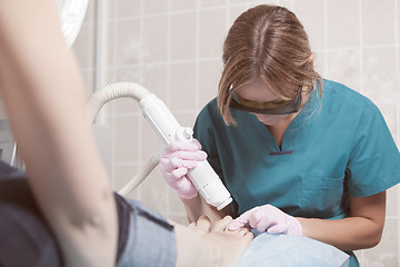 Image showing Female cosmetician doing foot therapy using laser