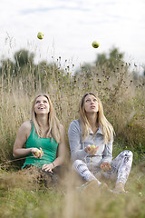 Image showing Two playful girls juggling outdoors