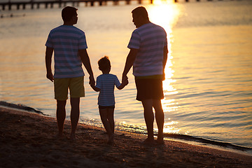 Image showing Three male generations by the sea at sunset