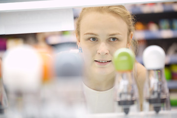 Image showing Young woman analyzing products in a store