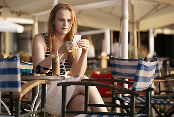 Image showing Woman sending an sms on her mobile