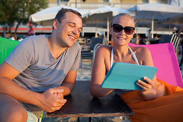 Image showing Man and woman with pad on the beach