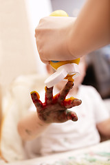 Image showing Young child playing with finger paint