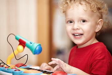 Image showing Adorable little boy playing with a toy microphone