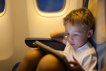 Image showing Boy sitting in the plane and using tablet PC