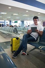 Image showing Young man using touch pad in the airport lounge