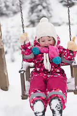 Image showing little girl at snowy winter day swing in park