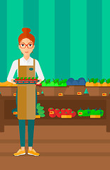 Image showing Supermarket worker with box full of apples.