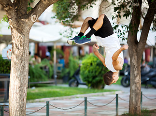 Image showing Young sportsman doing front flip in the street