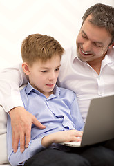 Image showing Father watching son working with laptop